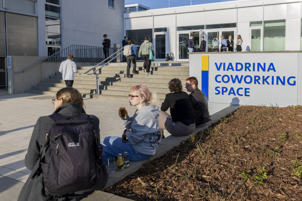 Europa-Universität Viadrina eröffnet Coworking Space.
Gemeinsames Band durchschneiden: Prof. Dr. Eduard Mühle, Präsident der Europa-Universität Viadrina, Dr. Manja Schüle, Ministerin für Wissenschaft, Forschung und Kultur des Landes Brandenburg, Jendrik Fabisch (studentisches Mitglied im Präsidialkollegium.
Zur Eröffnung sagte Brandenburgs Wissenschaftsministerin Dr. Manja Schüle: „Ein moderner Lern- und Arbeitsraum ist mehr als nur ein Gebäude – er ist ein Ort der Begegnung, der Konzentration, der kreativen Entfaltung. Der neue Coworking Space der Viadrina zeigt das in beeindruckender Weise: kein klassischer Seminarraum, keine Bibliothek im alten Sinne. Sondern ein offener Ort für Austausch und für neue Ideen. Und ein Ort, der sich nicht nur für Studierende und Beschäftigte der Viadrina, sondern für alle Bürgerinnen und Bürger der Stadt öffnet. Dieser Coworking Space ist Ausdruck einer veränderten Hochschulkultur, die wir vor dem Hintergrund multipler Herausforderungen dringend brauchen. Deswegen unterstützen wir die Schaffung von Räumen wie diesen auch gerne – weil die Zukunft nicht irgendwo anders beginnt, sondern genau hier.“

Auf rund 1.500 Quadratmetern kann hier künftig individuell und kooperativ gelernt, geforscht und gearbeitet werden. Fünf Jahre lang wurde das Gebäude für insgesamt 17,5 Millionen Euro umgebaut. Entstanden ist ein innovativer, flexibel nutzbarer Raum, der Studierenden, Beschäftigten und Gründenden der Viadrina als Lehr- und Arbeitsort dient sowie Begegnungen zwischen Stadt und Universität ermöglicht.
Der Viadrina Coworking Space bietet verschiedene Areale – vom großzügigen Begegnungsbereich über flexible Lern- und Arbeitsräume, bis zum kreativen Gründungsbereich. Er befindet sich zwischen Audimax und Studierendenwohnheim in einem früher als Mensa genutzten Gebäude. Zu den zentralen Elementen des Coworking Space gehören sieben bis zu 40 Quadratmeter große Lichtschächte aus Glas, die aus dem D