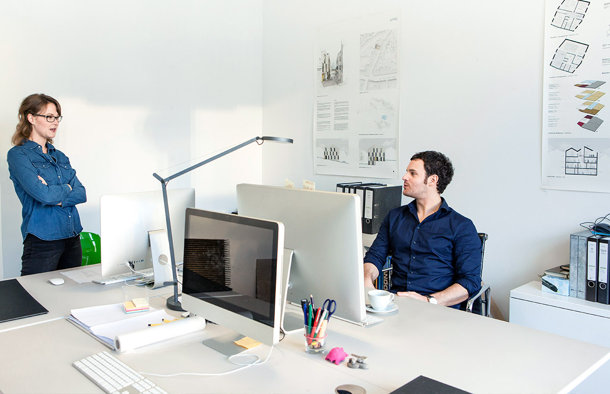 Fachlicher Austausch zwischen Mitarbeitenden im Büro zu laufenden Planungsprojekten
